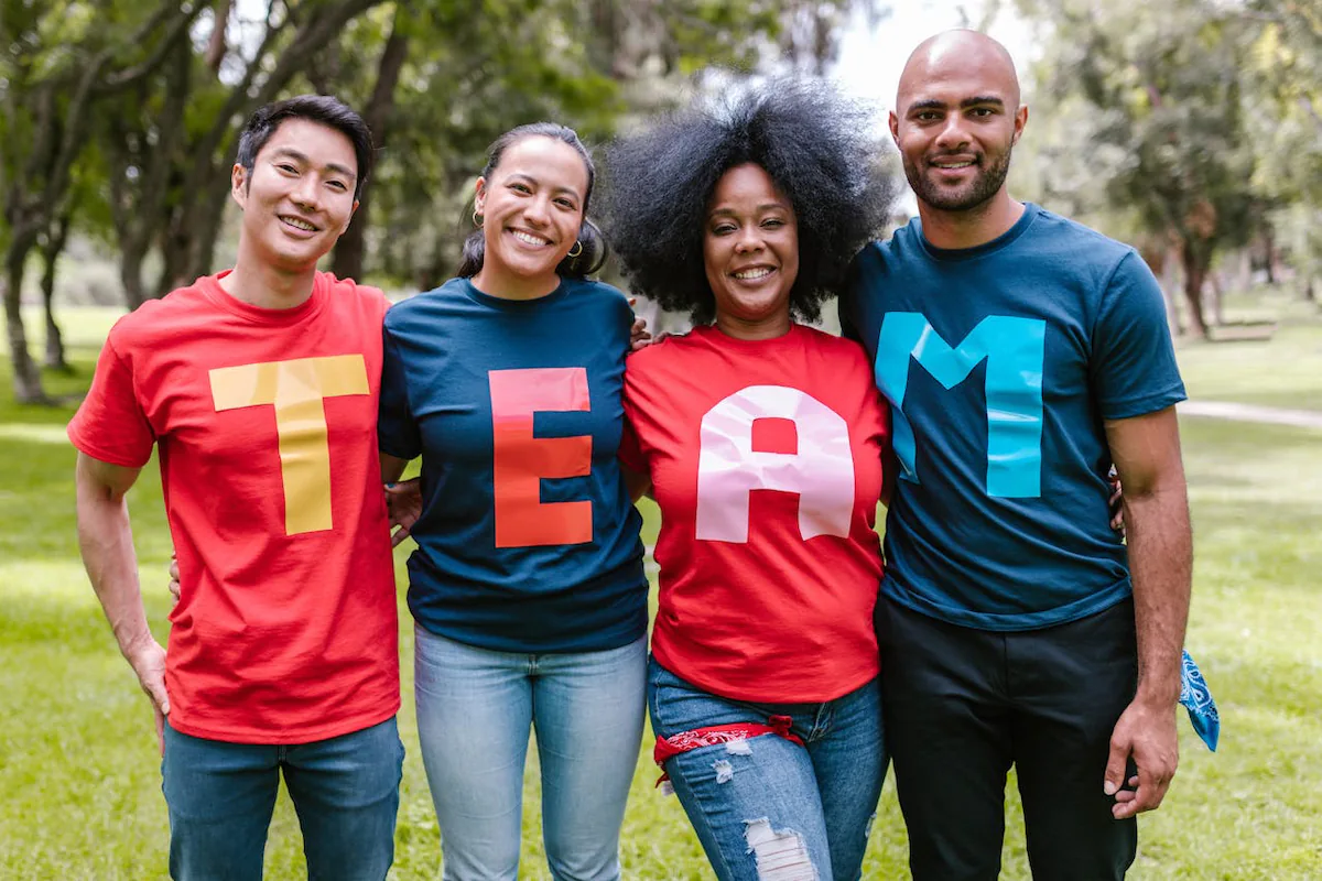 Full-team incentive - image of four smiling people wearing t-shirts that spell out TEAM