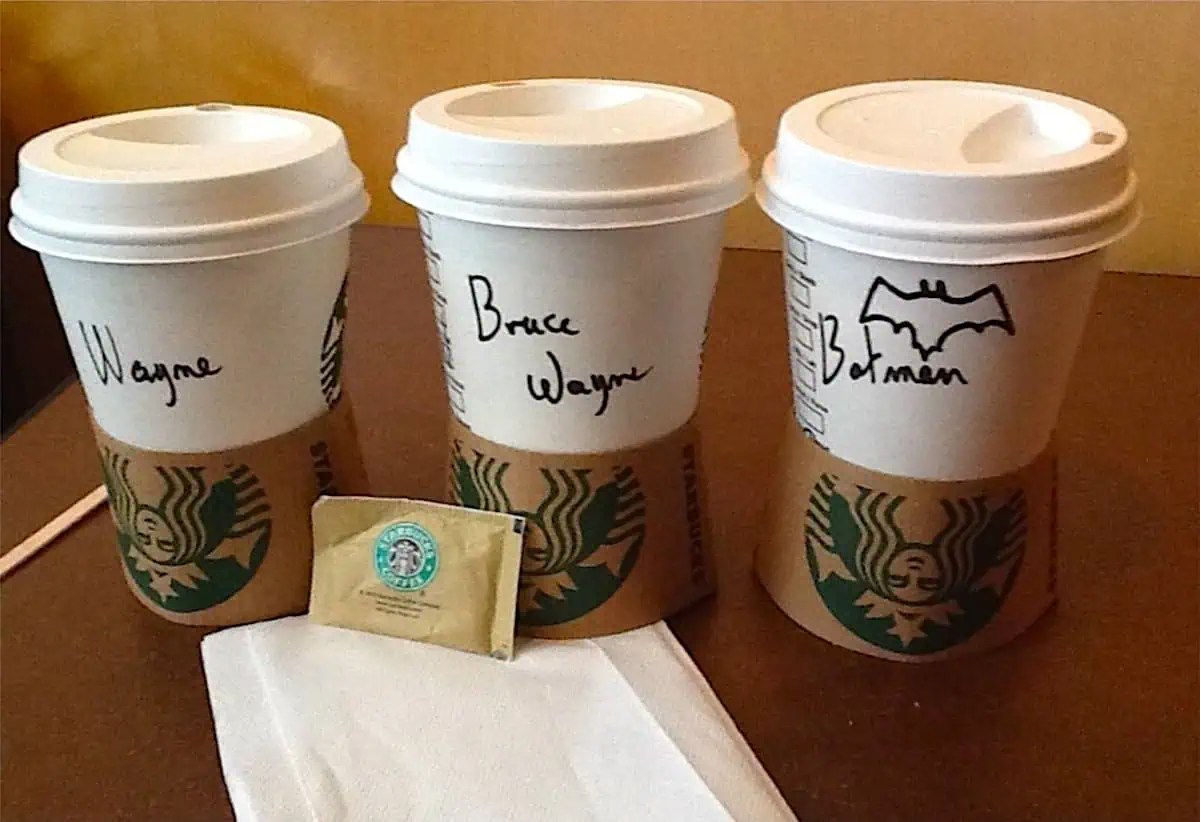 Three Starbucks cups with the names "Wayne", "Bruce Wayne" and "Batman" on them
