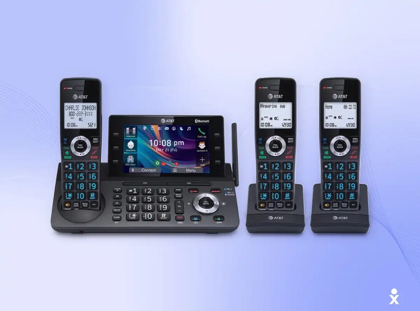 An AT&T office phone system with a central base and three cordless handsets.