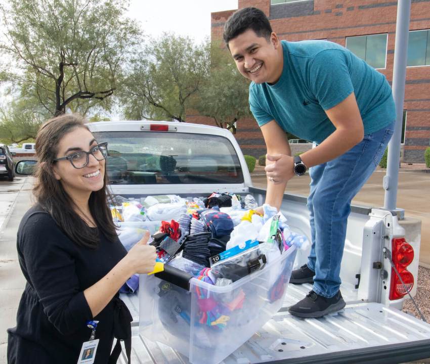 More than a thousand pairs of socks were collected from Nextiva. Pictured: Shula Resendez and Andrew Ruiz.
